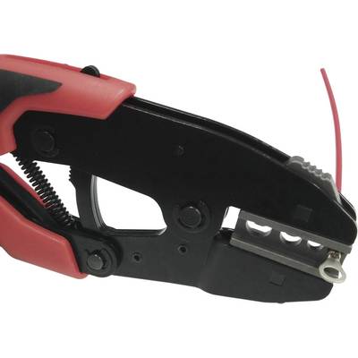 Pince à dénuder noir et rouge coupe un câble rouge. Outil pour dénuder les câbles dans les applications électriques.