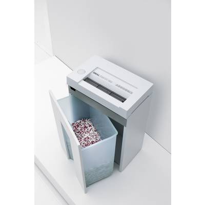 Un destructeur de documents avec un bac de collecte ouvert, rempli de morceaux de papier déchiquetés. L'appareil est posé sur un sol blanc.