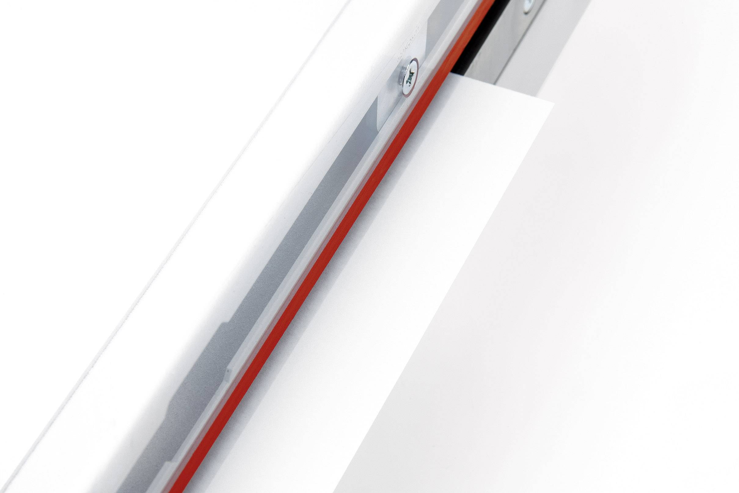 Une feuille blanche est introduite dans une fente étroite et argentée, probablement partie intégrante d'une imprimante ou d'un scanner.