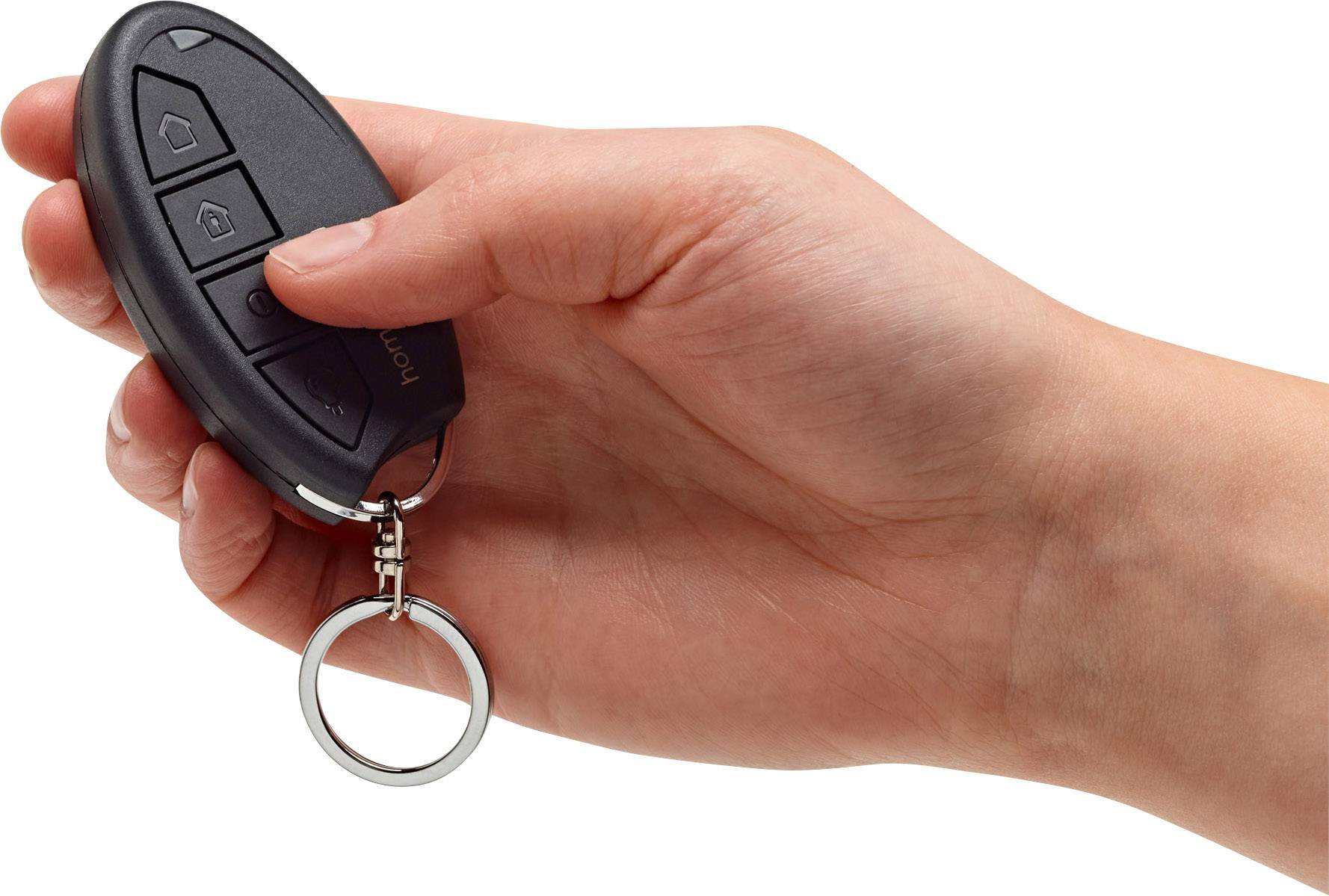 Une main tient une clé de voiture noire à trois boutons. La clé est équipée d'un anneau métallique.
