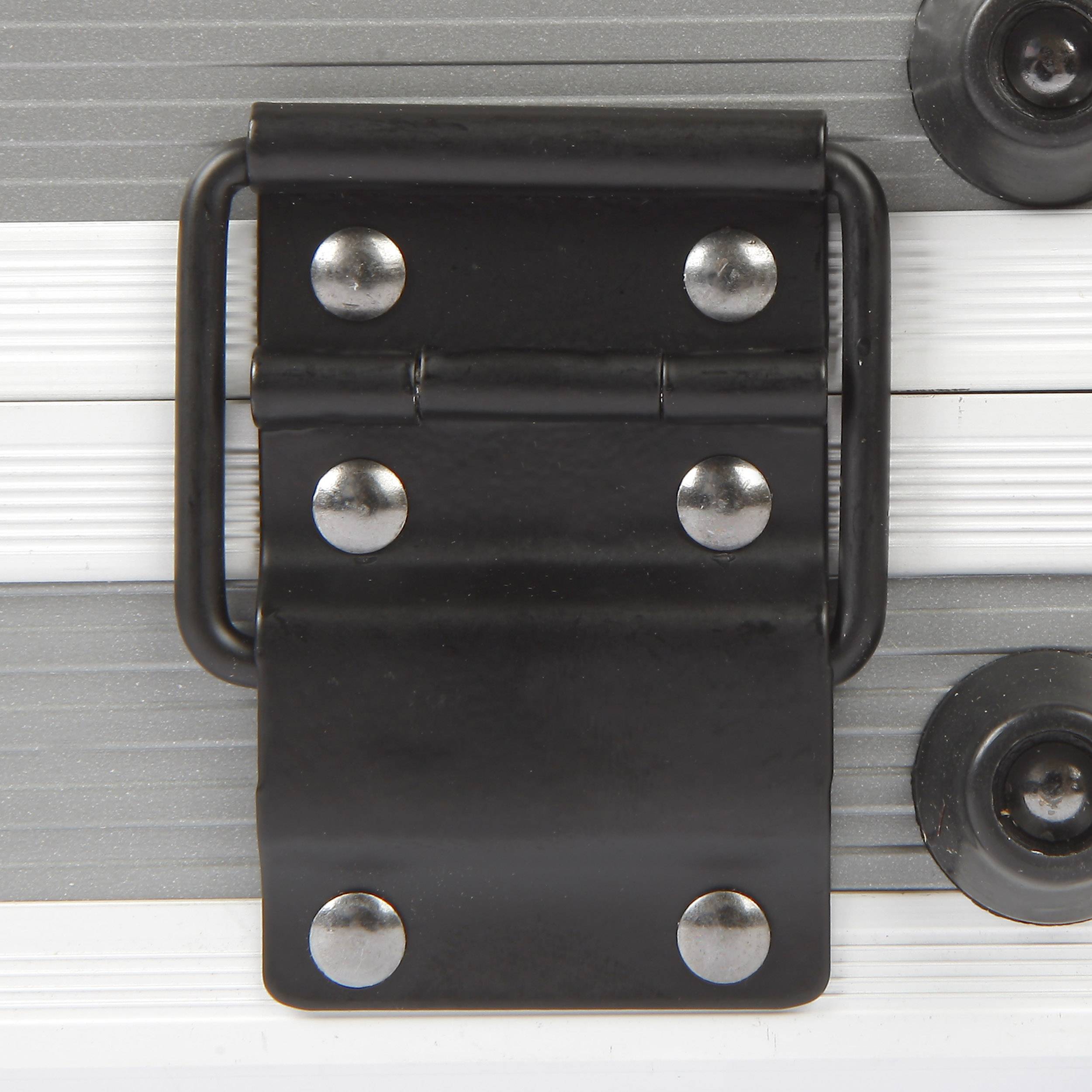 Bande métallique avec charnière noire, fixée par des rivets sur une surface structurée. Composants ronds adjacents en argent.