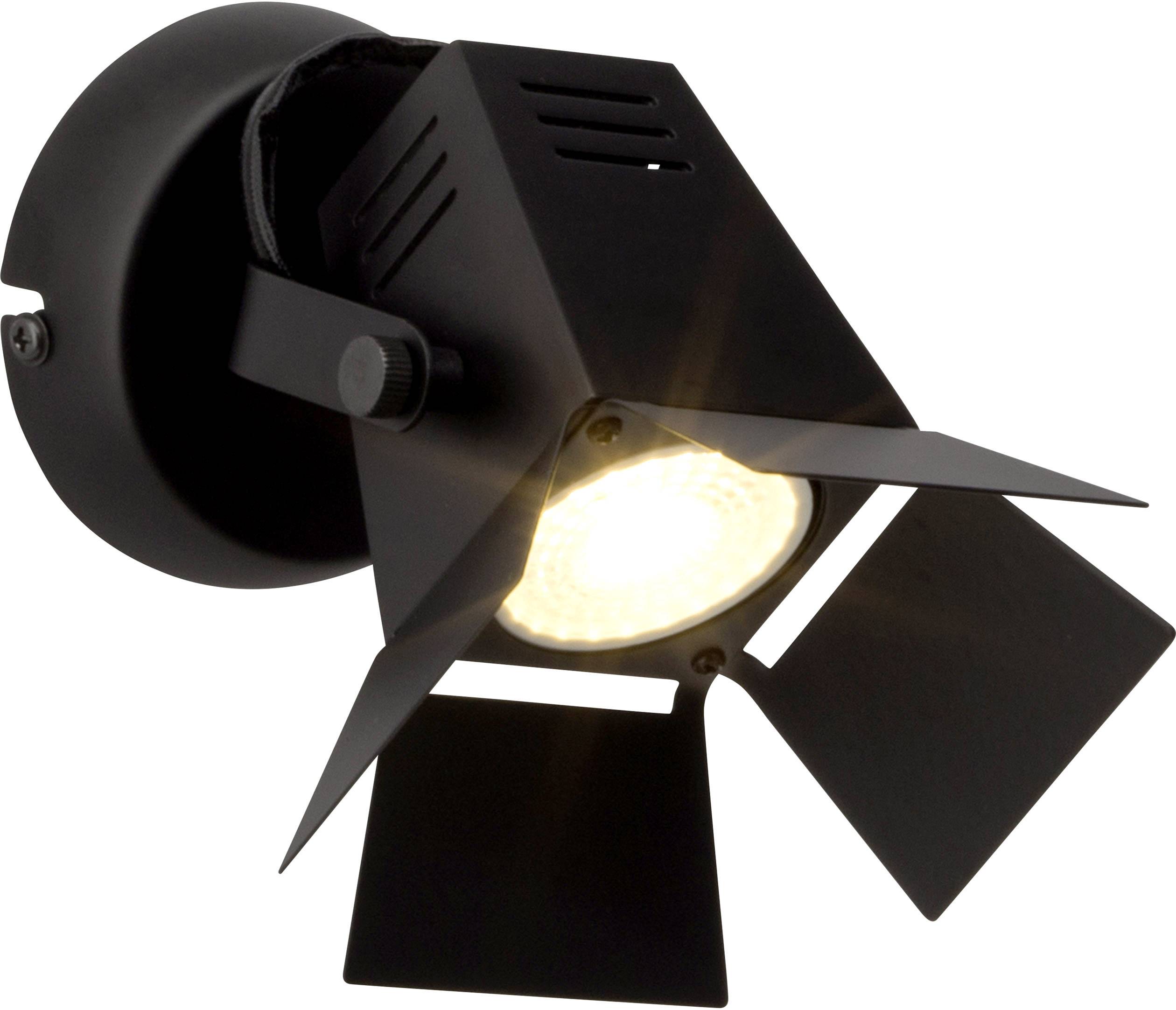 Un projecteur noir avec des volets ajustables, diffusant une lumière vive, monté sur un mur.