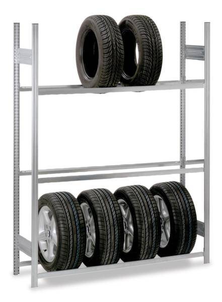 Étagère à deux niveaux. En haut, deux rangées de pneus verticaux, en bas, cinq pneus de voiture montés. Adapté au stockage des pneus dans les ateliers.