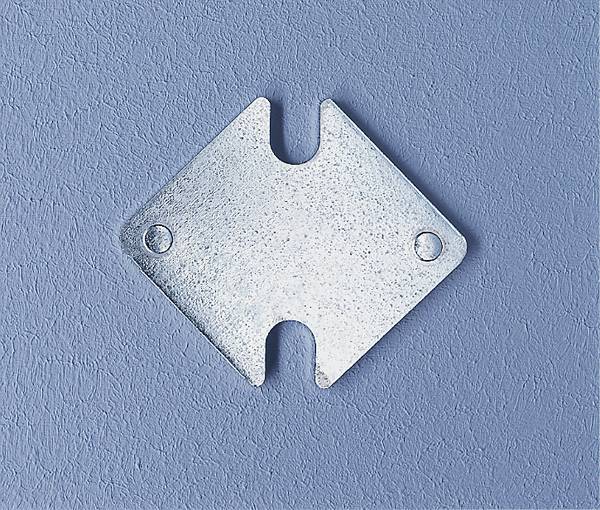 Un objet métallique en forme de flèche est posé sur une surface bleue. Il présente deux trous, un de chaque côté de la flèche.