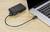 Une caméra numérique est connectée à un ordinateur portable via un câble USB. L'ordinateur portable montre un clavier partiellement ouvert.