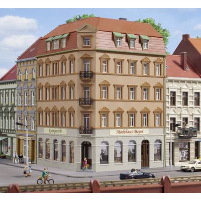 Une boutique à la mode 'Maison Meyer' est visible dans un bâtiment historique à plusieurs étages, situé à l'angle d'une rue animée.