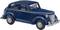 Une voiture miniature bleu foncé représentant une voiture ancienne classique à quatre portes, avec des détails précis comme des phares et des roues.