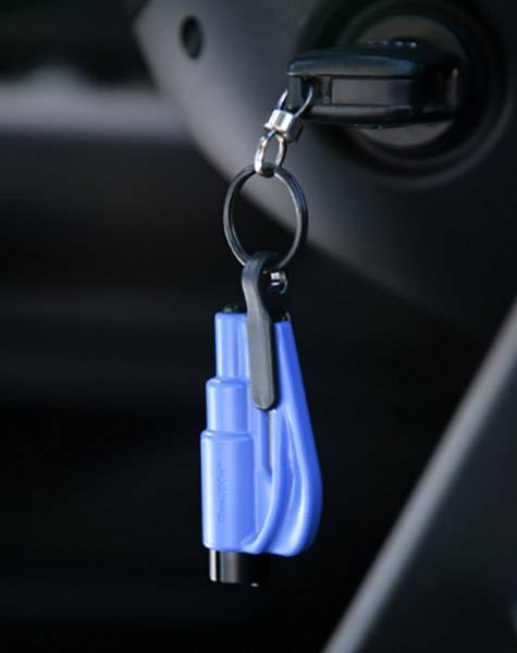 Un marteau de sécurité bleu est accroché à un trousseau de clés dans le contact d'un véhicule.