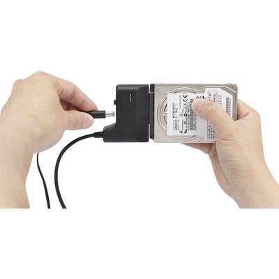 Une personne tient un disque dur et le connecte avec un câble réseau. Elle prépare un branchement de disque dur externe.