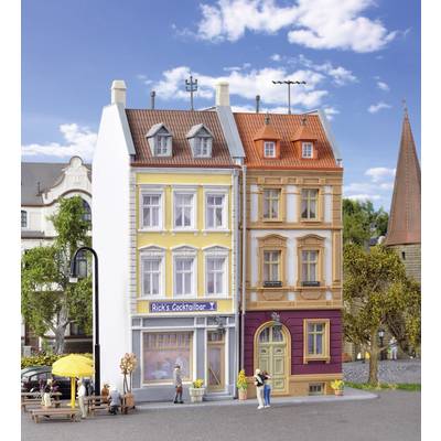 Deux bâtiments étroits sur trois étages avec un panneau 'Rick's Cocktailbar'. Une zone piétonne avec un parasol jaune au premier plan.