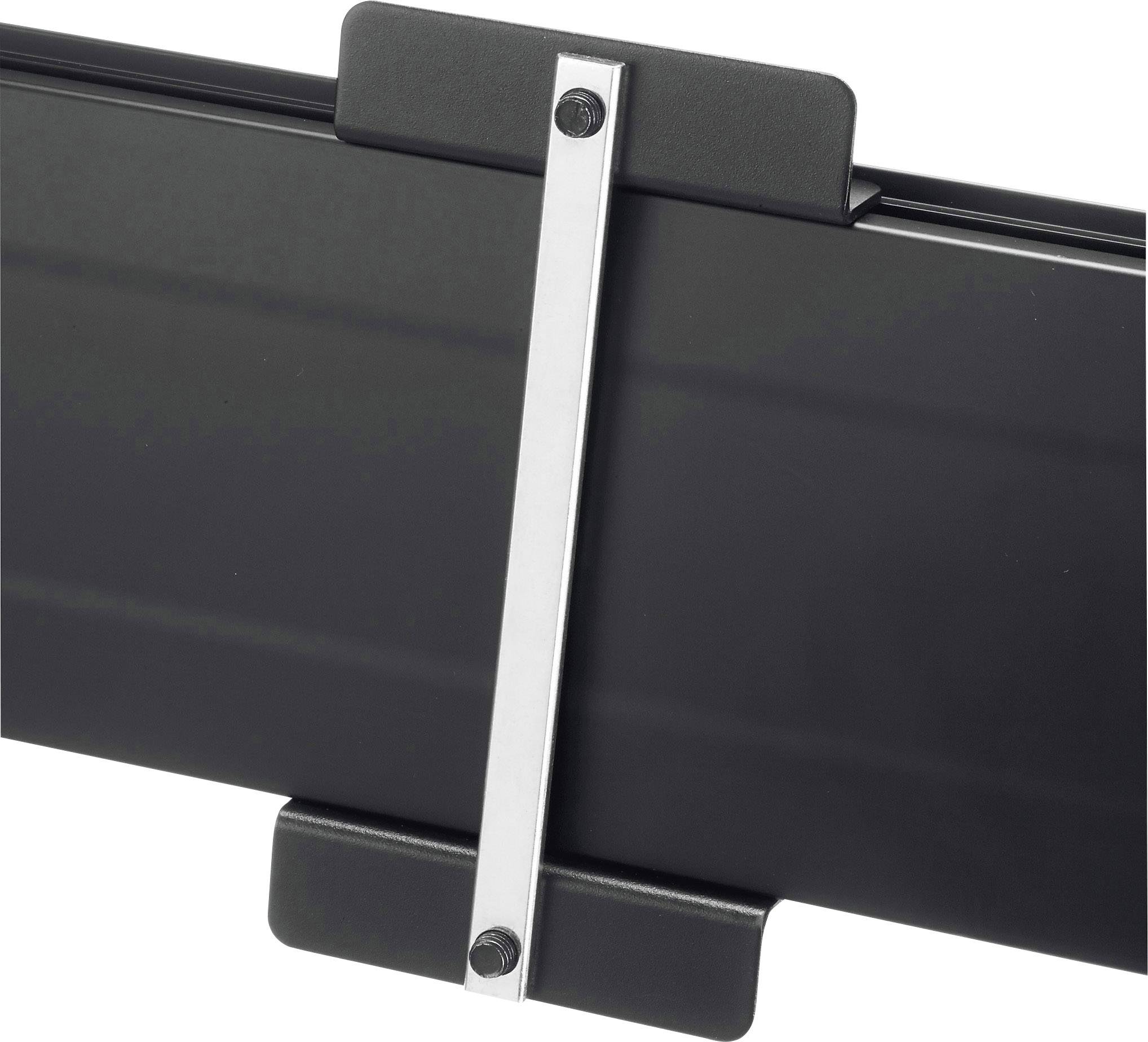 Gros plan d'un lingot métallique noir avec une barre argentée fixée par des vis.