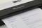 Un scanner portant l'inscription 'IRIScan Executive' numérise un document contenant du texte sur l'expérience professionnelle et les centres d'intérêt.