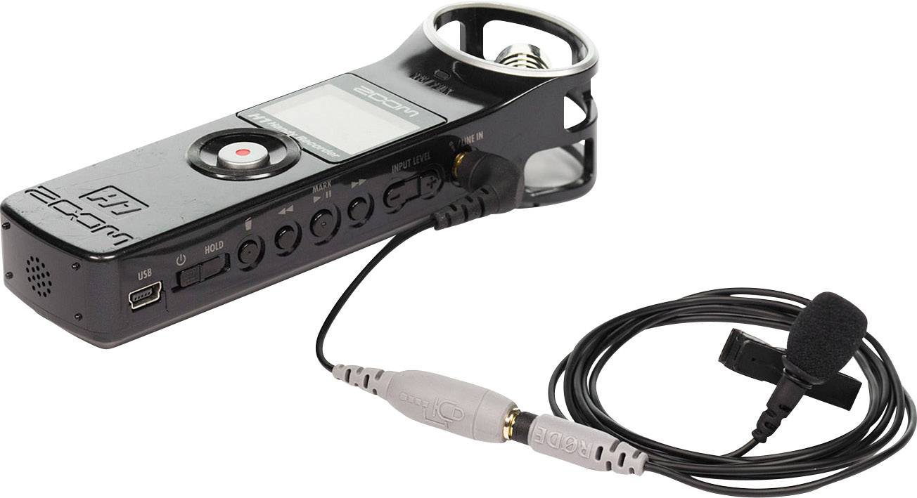 Enregistreur audio portable avec écran et touche d'enregistrement, accompagné d'un microphone à clipser. Idéal pour les interviews et les enregistrements musicaux.