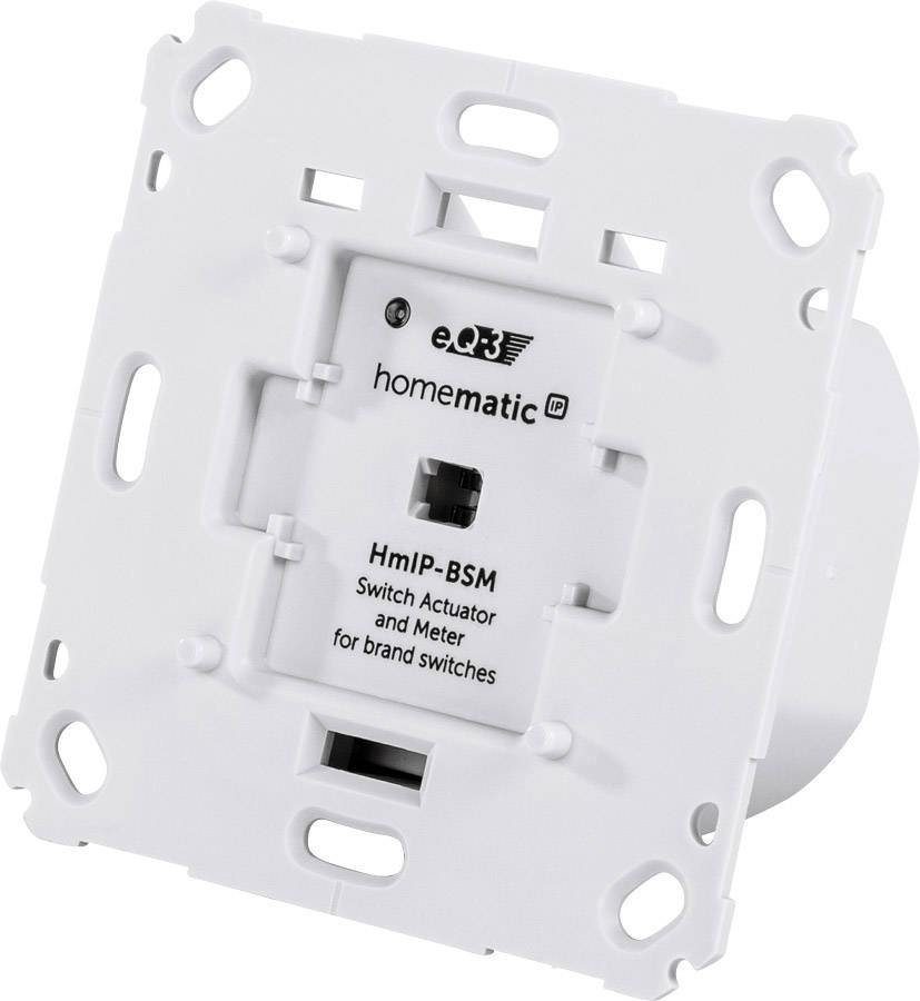 Un actionneur de commutation Homematic IP blanc (modèle HmIP-BSM) pour le contrôle des interrupteurs lumineux. Forme rectangulaire avec plusieurs trous de montage.