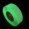 Un rouleau de ruban adhésif vert fluorescent sur un fond noir.