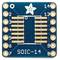 Platine adaptateur SOIC-14 avec broches numérotées. Un logo floral en haut à gauche. Conçue pour souder des circuits intégrés à 14 broches.