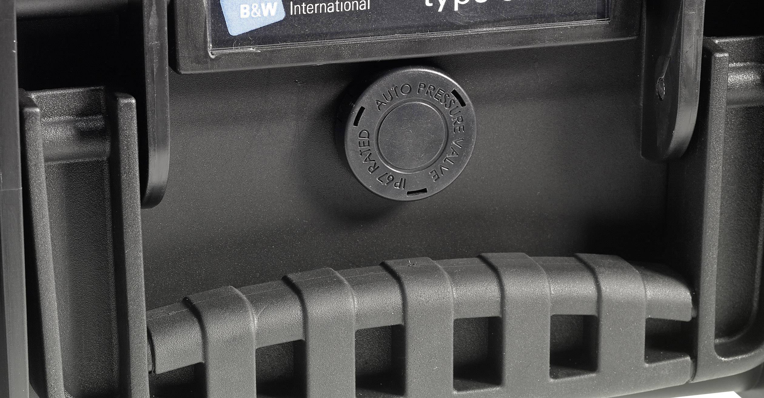 Gros plan d'une valise noire avec poignée et soupape d'équilibrage de pression, le logo de marque 'B&W International' étant visible.