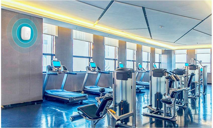 Une salle de fitness moderne avec plusieurs tapis de course et appareils de musculation. À l'arrière-plan, de grandes fenêtres laissent entrer la lumière du jour.