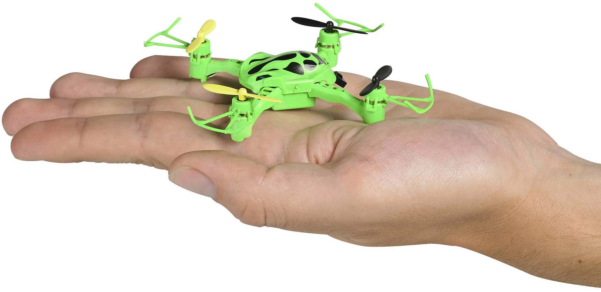 Un petit drone vert à quatre rotors est posé sur une main tendue, illustrant sa taille.