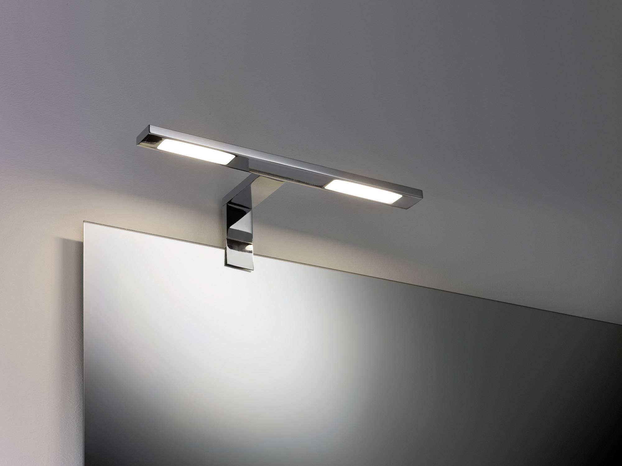 Applique murale au design moderne au-dessus d'un miroir, illuminant la pièce avec éclat.