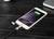 Un smartphone est posé sur une table et est en train de se charger. L'écran affiche « 100% chargé ».