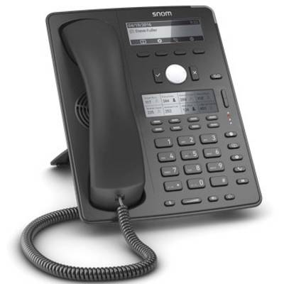 Un téléphone de bureau noir avec un écran et un clavier numérique, posé sur une table. L'écran affiche le nom 'Steve Fuller'.