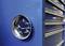 Des vis métalliques adhèrent à un récipient magnétique rond, fixé à une armoire à outils bleue.