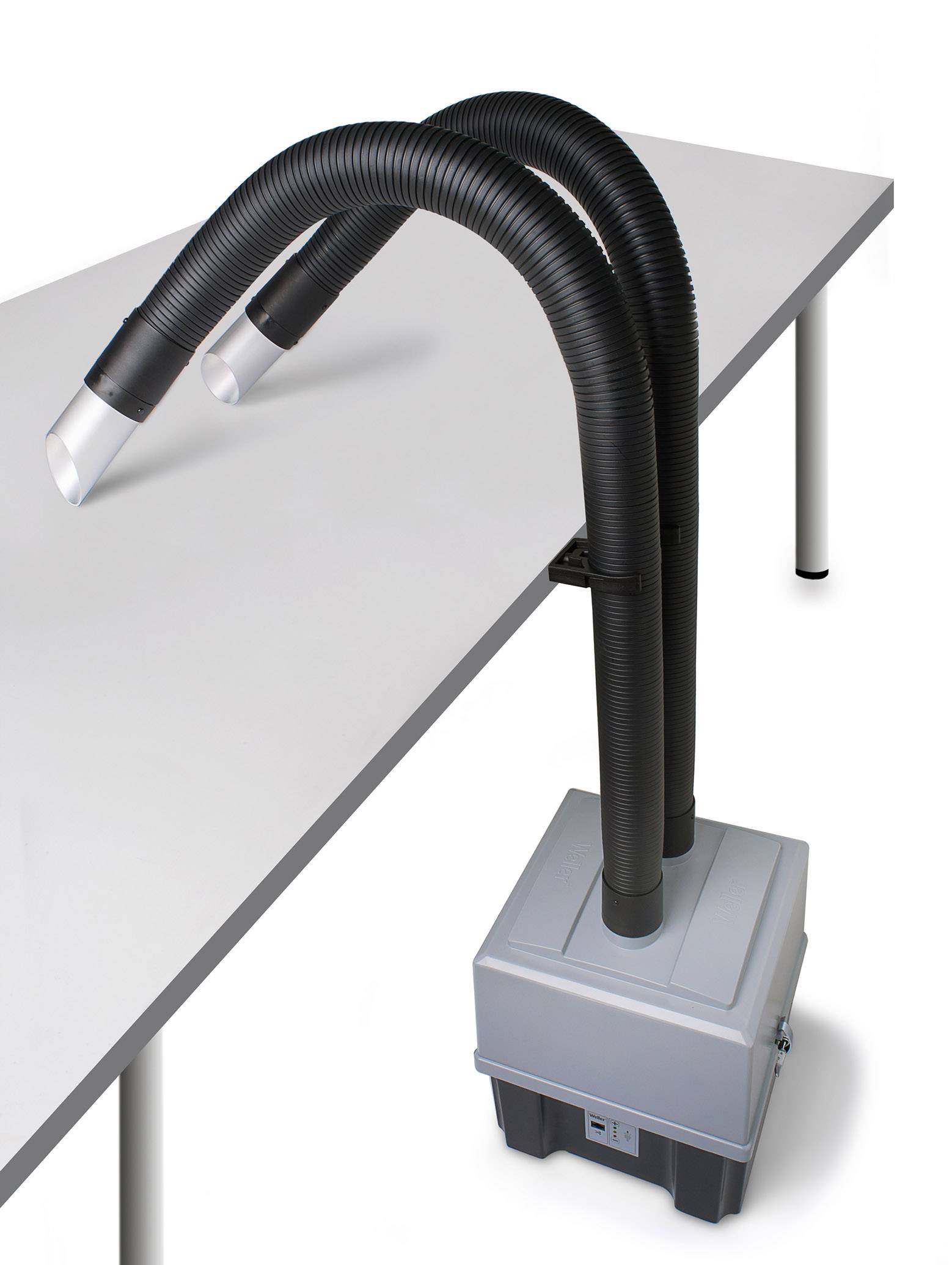 Aspirateur portable de fumée avec deux tuyaux flexibles, fixé à un boîtier gris. L'appareil est posé sur une table.