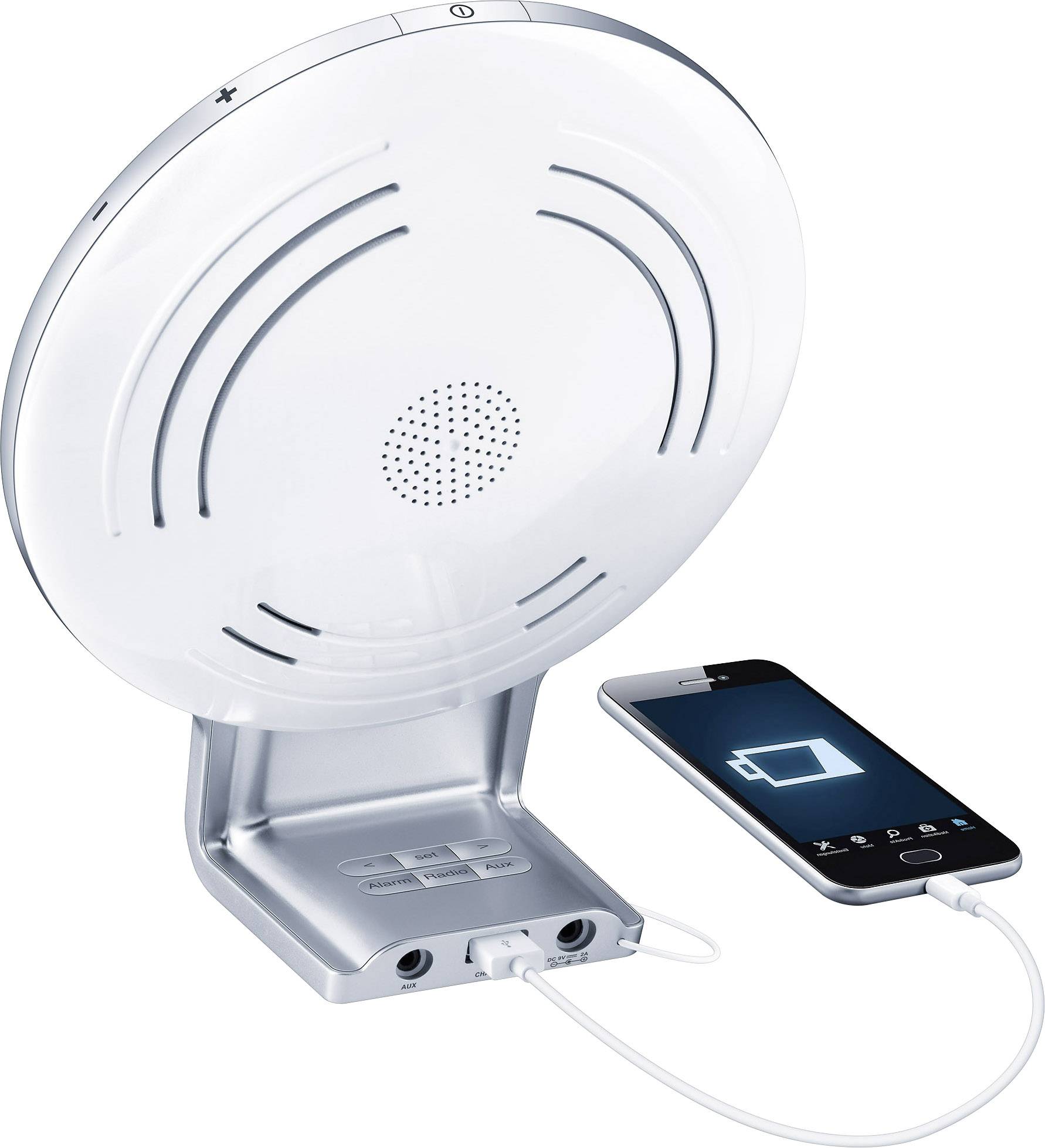 Un réveil radio blanc avec un smartphone connecté affiche un symbole de charge. L'appareil est équipé de haut-parleurs et de touches de commande.