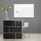 Un espace moderne et minimaliste avec un comptoir noir, sur lequel repose un vase de fleurs, et une chaise blanche sur le côté.