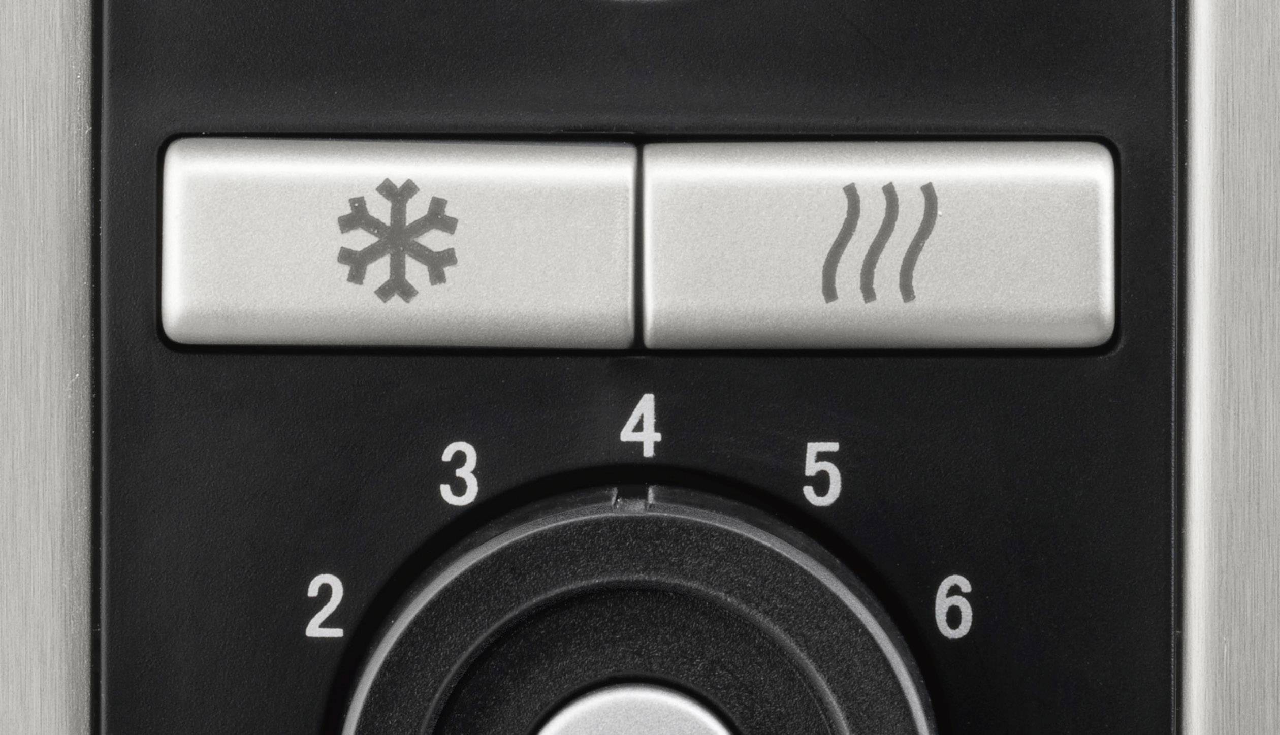 Gros plan sur un panneau de commande avec deux boutons : l'un avec un symbole de flocon de neige pour le froid, l'autre avec trois lignes ondulées pour la chaleur ; en-dessous, un bouton rotatif portant les chiffres de 1 à 6.