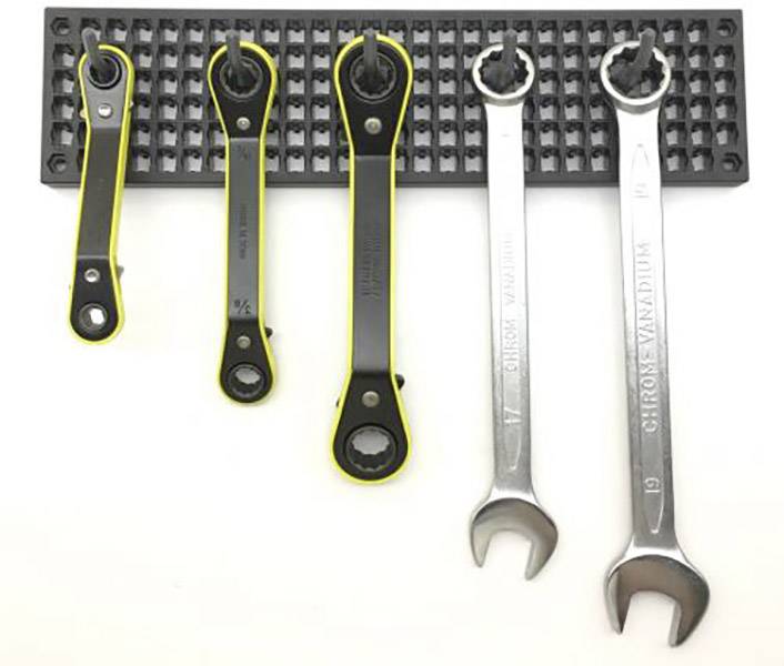 Cinq clés à molette de différentes tailles sur un support noir, deux en métal, trois avec un contour jaune, sur un fond blanc.