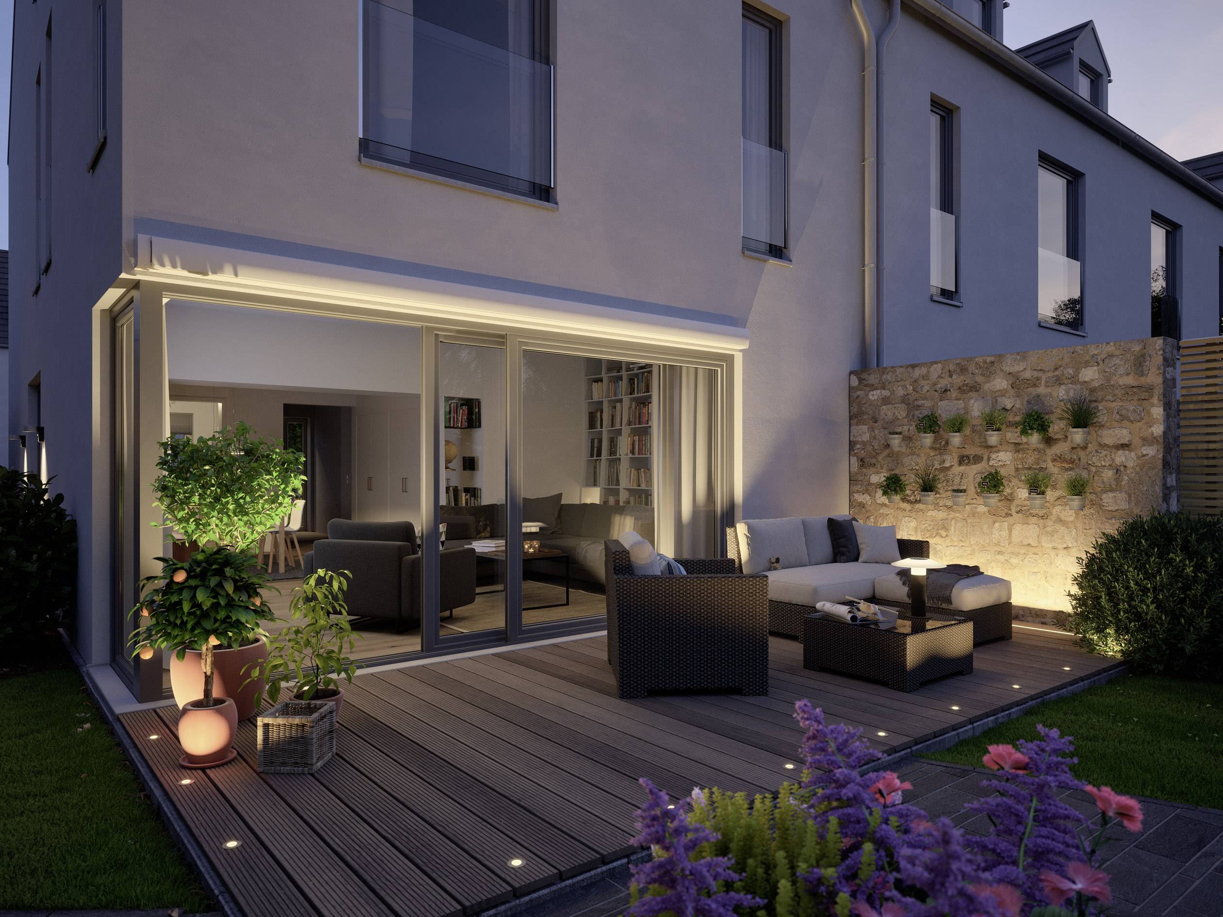 Terrasse moderne au crépuscule avec des meubles d'extérieur confortables, des plantes et un éclairage indirect devant une maison contemporaine.