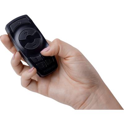 Une main tient une télécommande noire avec des touches pour régler le volume et un interrupteur marche/arrêt.