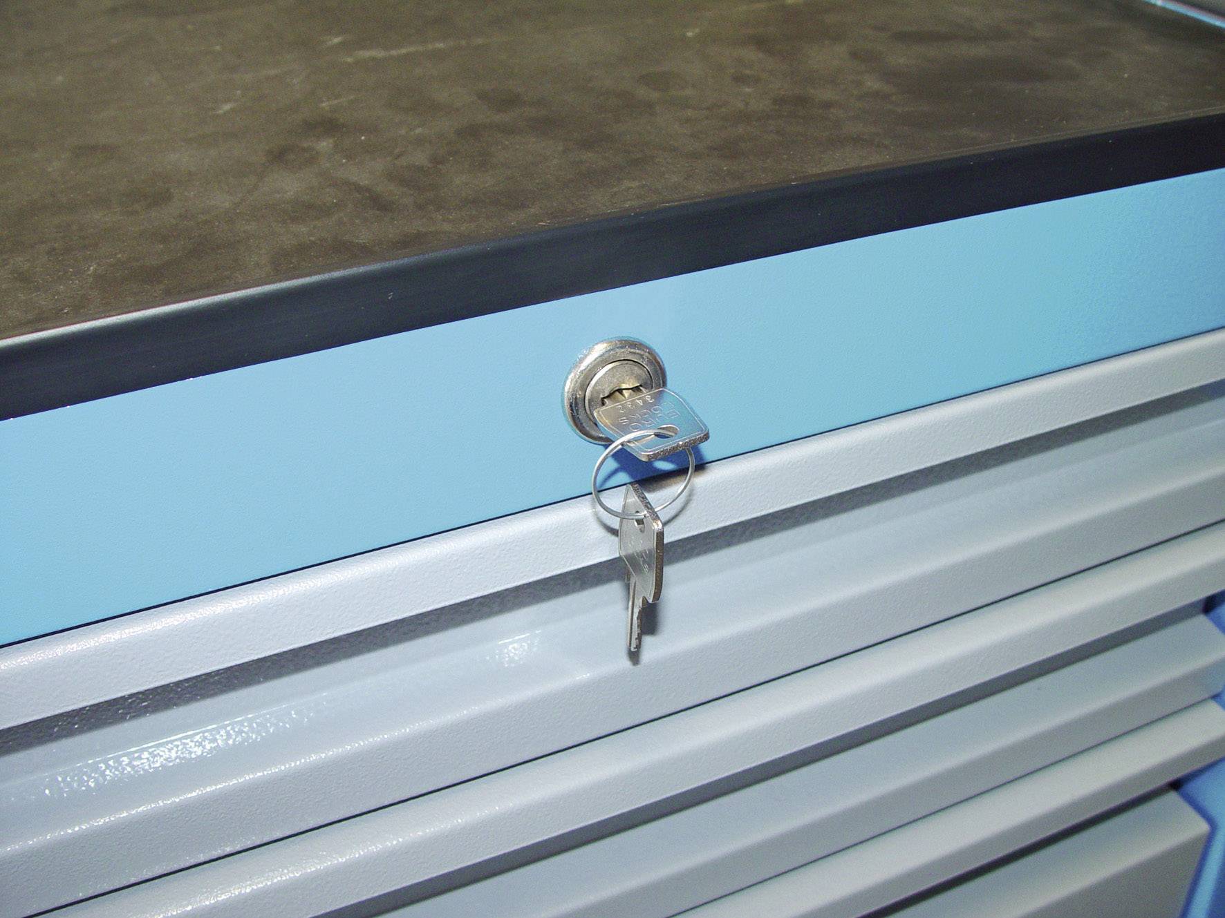 Tiroirs métalliques bleus avec une clé insérée dans une serrure, une surface de travail noire posée dessus.