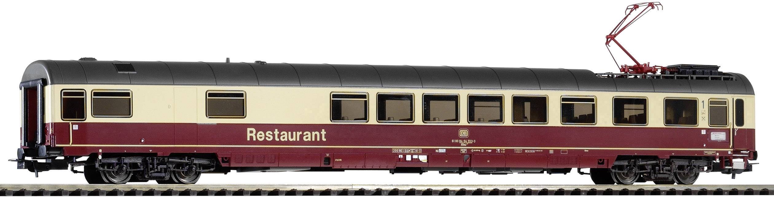 Un wagon-restaurant de train miniature peint en beige et rouge, exposé sur des rails. Une structure de collecteur de courant est visible en haut.