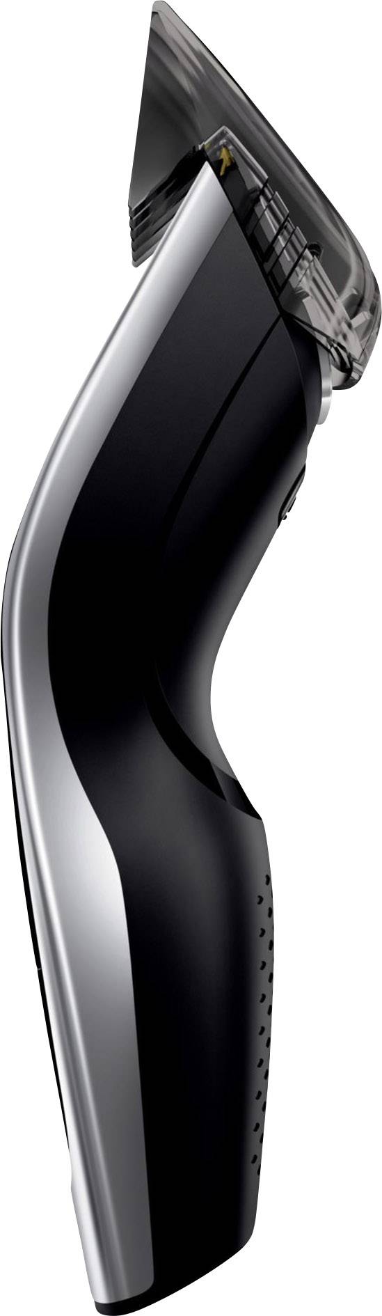 Tondeuse électrique vue de profil, avec un design ergonomique en noir et gris, montrant les lames et la zone de préhension.