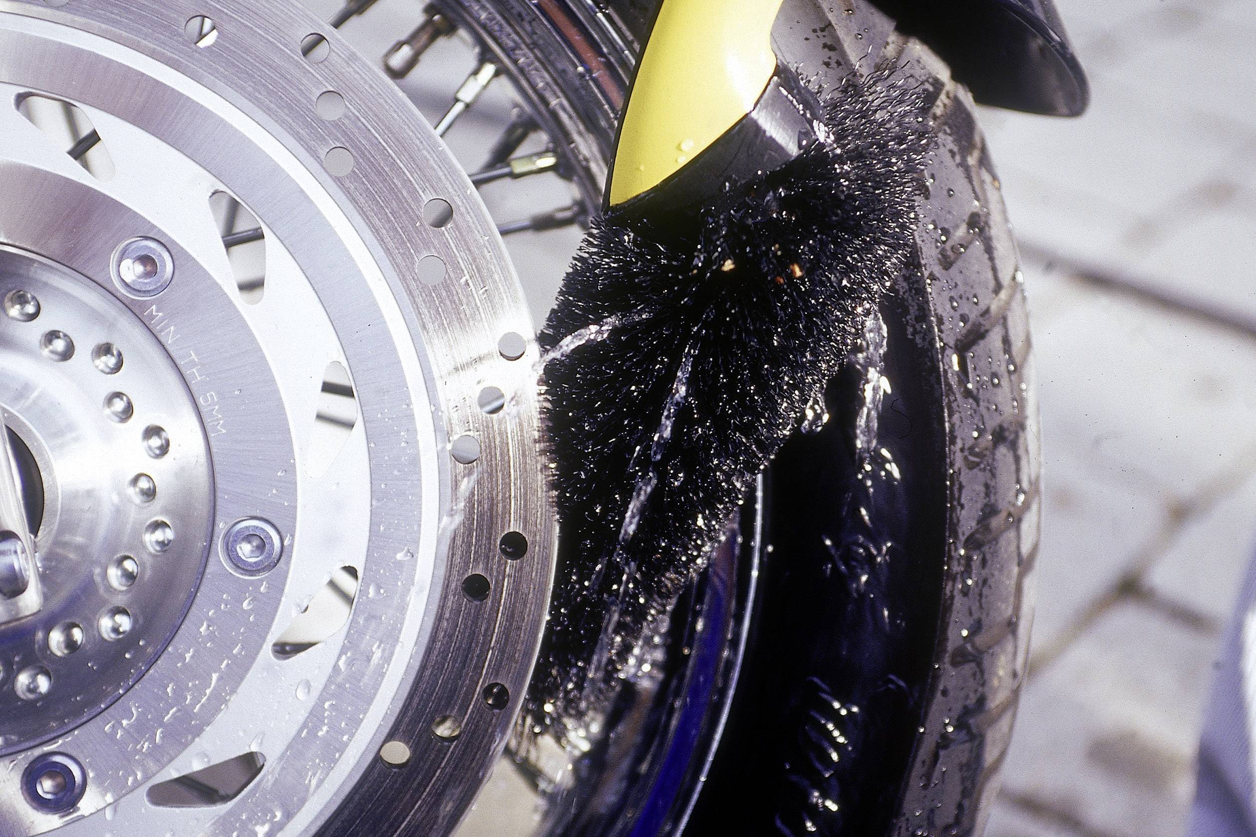 Un pare-éclaboussures sur un pneu de moto qui repousse l'eau pour empêcher les projections sur les routes mouillées.