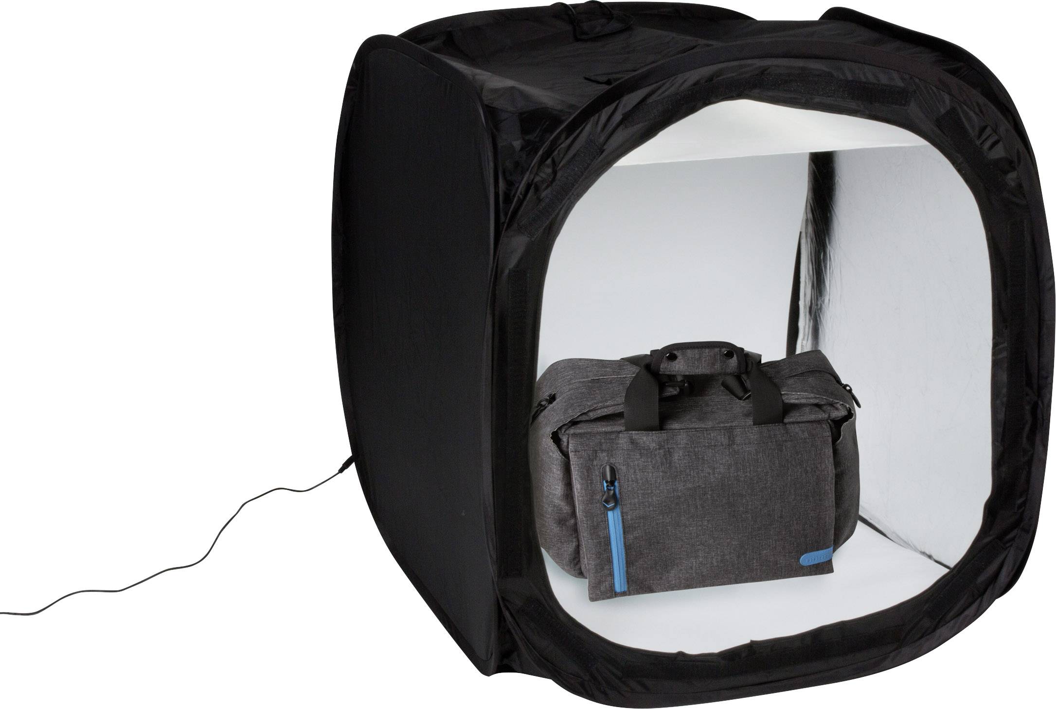Un studio photo noir avec un éclairage ; à l'intérieur se trouve un sac gris avec des accents bleus.