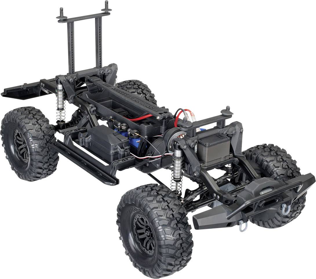 Châssis de voiture télécommandée avec groupe motopropulseur et suspension apparents, présenté sur un fond clair.