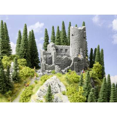 Un diorama miniature représente les ruines d'un château sur une colline boisée, entourées de sapins et d'herbes, avec des personnages en train de marcher.
