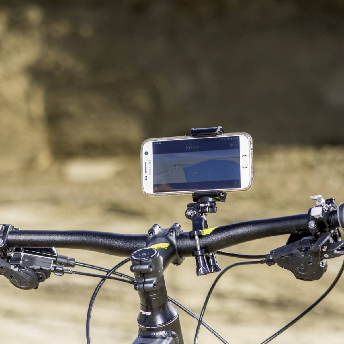 Smartphone monté sur un support de guidon de vélo avec une application de navigation ouverte, affichant un itinéraire ; arrière-plan flou.