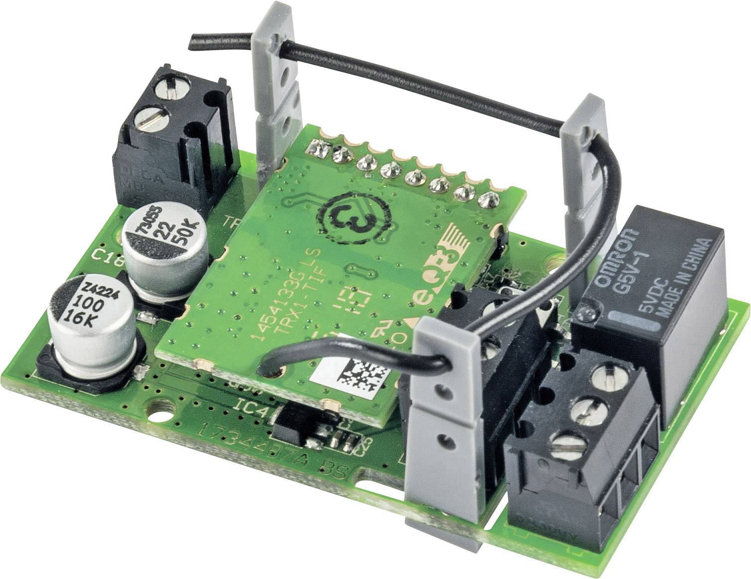 Une carte électronique verte avec plusieurs condensateurs, circuits électroniques et connexions de câbles, reposant sur un support de montage.