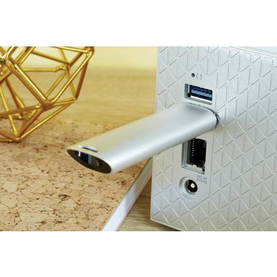 Une clé USB argentée est insérée dans un appareil moderne présentant un motif géométrique sur sa face arrière. À côté, plusieurs ports sont visibles.