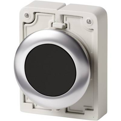 Un grand bouton rond avec un bord argenté sur un fond rectangulaire crème. Le bouton a une surface noire.