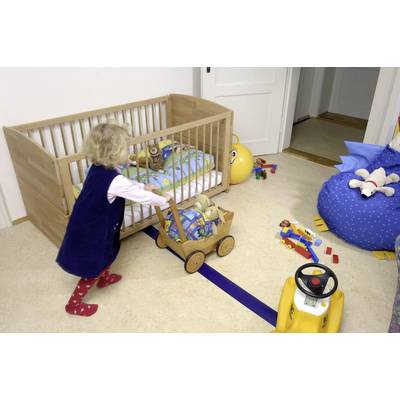 Un petit enfant joue dans une chambre d'enfant. Il pousse un chariot en bois rempli de jouets. En arrière-plan, un lit à barreaux est installé.