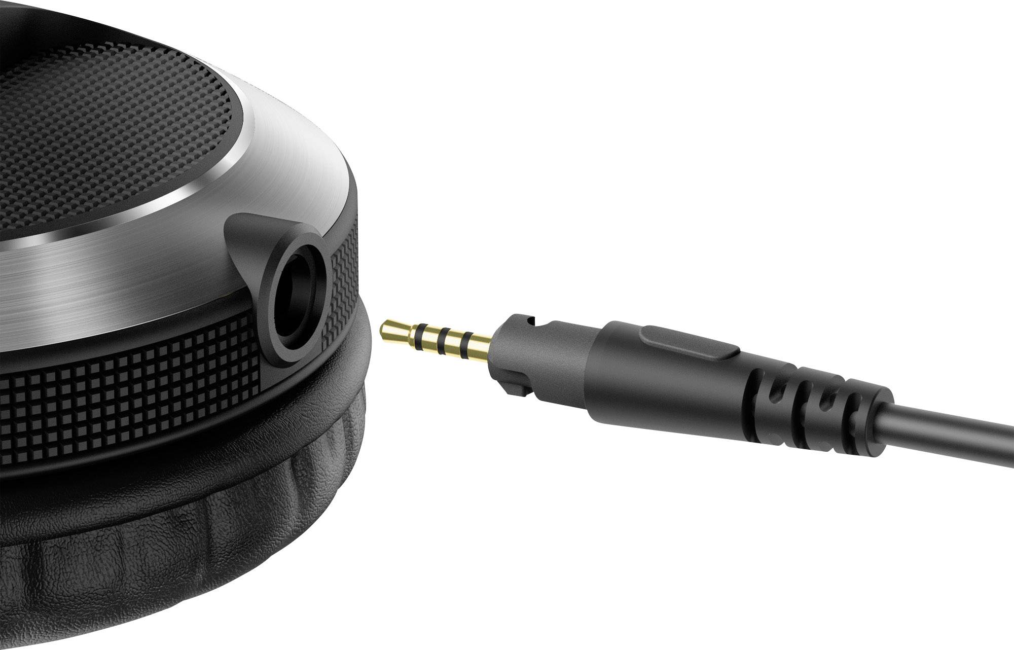 Un casque noir est posé à côté d'une prise jack 3,5 mm, comme s'il était sur le point d'être branché.