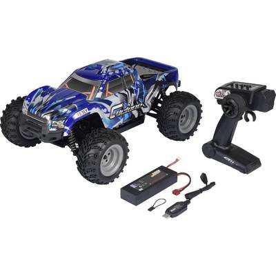 Une voiture tout-terrain télécommandée bleue avec de grandes roues, à côté de sa télécommande, de son pack batterie et de son câble de charge, prête à être utilisée.