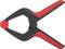 Une pince à ressort en plastique noir et rouge, ouverte, montrant ses mâchoires. Principalement utilisée pour des projets de bricolage ou des travaux manuels.