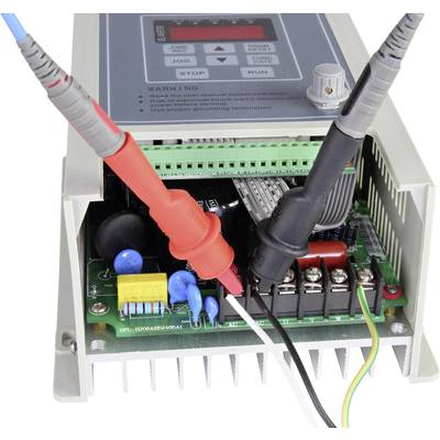 Appareil électronique avec boîtier ouvert ; montre une carte mère verte avec des pointes de test connectées.